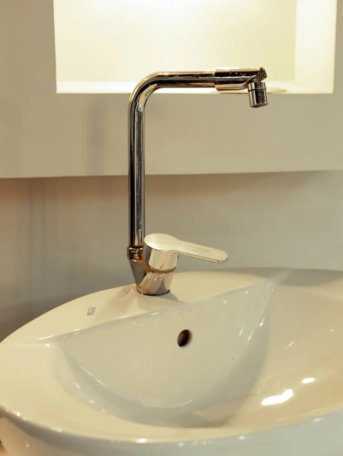 A white bathroom vessel sink with a chrome faucet